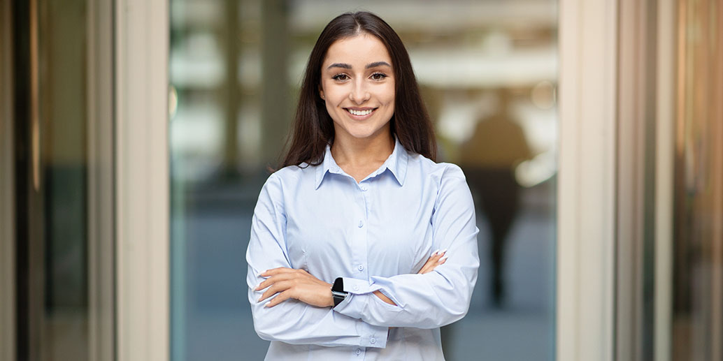 Femme brune consultante en développement durable en chemise bleu, sourit à la camera