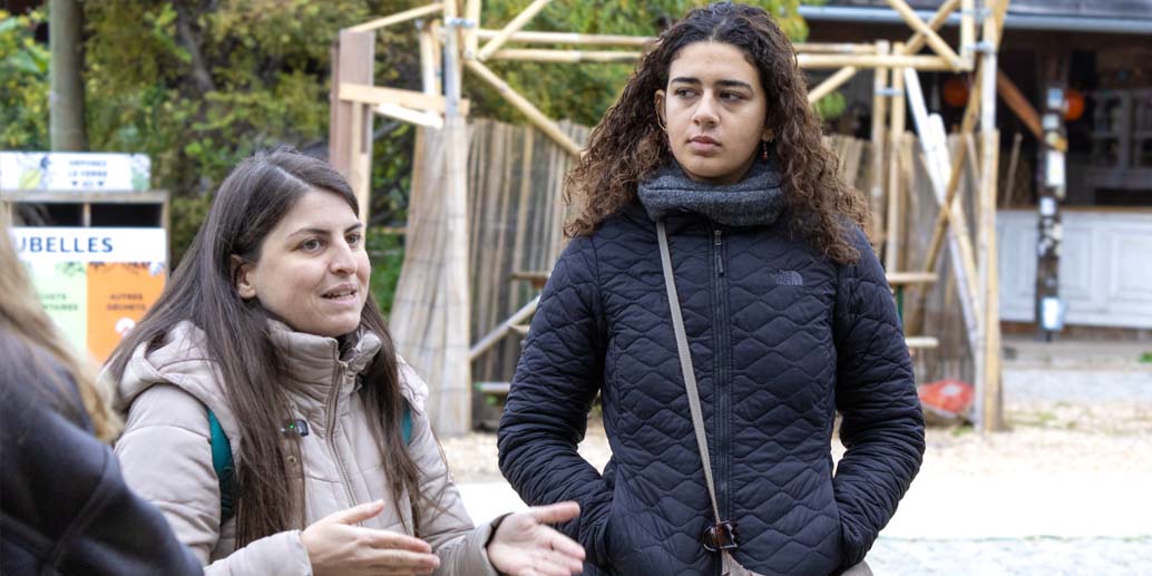 June femme au centre avec cheveux bouclés qui regardent une deuxième femme plus petite sur la gauche