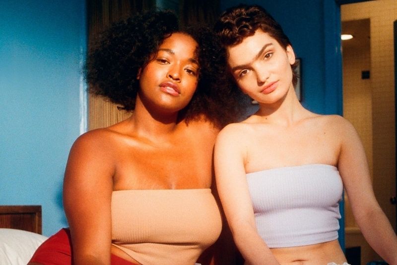femme noire et femme blanche posant dans une chambre