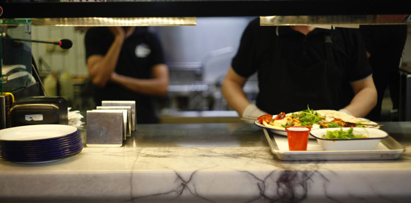 Personne préparant un plateau-repas dans une cantine